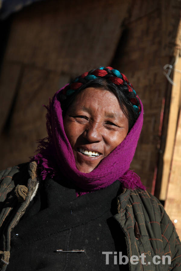 A Tibetan woman wearing a scarf smiles. Lhoka, a glorious place with remarkable people, is the cradle of Tibetan civilization. [Photo/China Tibet Online]