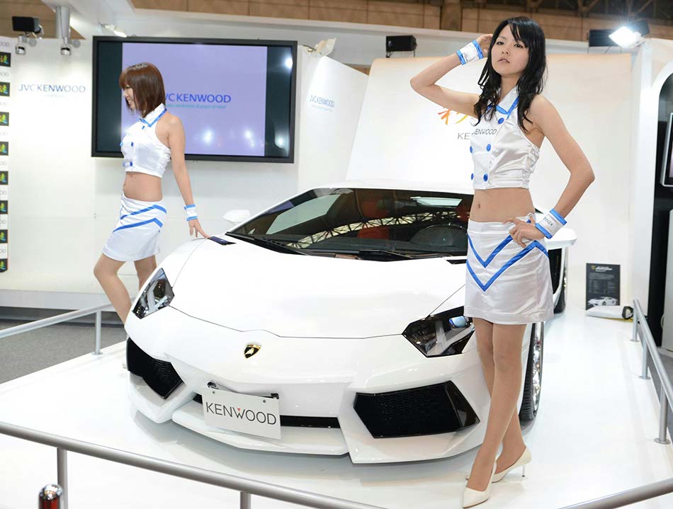 Models pose next to a modified Lamborghini car at the Tokyo modified car show on Jan 11, 2013 in Tokyo. (Photo / Xinhua) 
