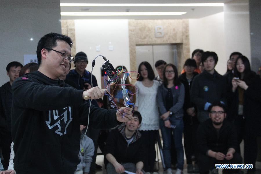 Maker Liu Yang demonstrates the newly-designed photographic stablization device for cell phones during the Art and Tech Hackathon, an innovation competition organized by a hackerspace Beijing Maxpace, in Beijing, capital of China, April 14, 2013. Some 23 makers participated in the competition. (Xinhua/Ma Ping)