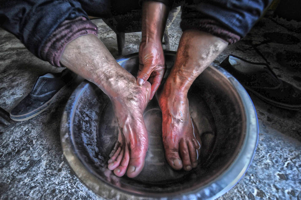 Li Rushuan washes his feet after his routine patrol on the railway on April 10, 2013. Li has been patrolling back and forth like a pendulum for more than 3 decades on the railway, accumulating 100,000 kilometers. (Photo by Fan Minda/ Xinhua)