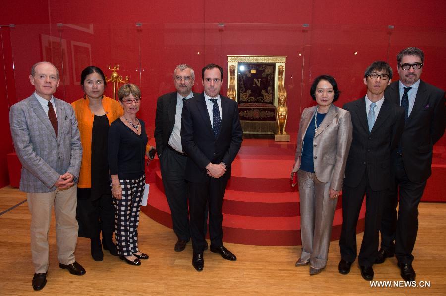 Honored guests pose for pictures with Napoleon Bonaparte's throne to be displayed at an exhibition of furniture and ornaments from the Fontainebleau Palace from 1804 to 1815 in south China's Macao, April 15, 2013. The exhibition will be held from April 18 to July 14 at Macao Museum of Art . (Xinhua/Cheong Kam Ka)