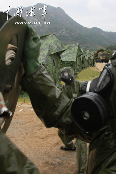 A shore-based mobile anti-ship-missile regiment under the South China Sea Fleet of the Navy of the Chinese People's Liberation Army (PLA) organized a NBC (nuclear, biological and chemical) defense drill against actual-combat background on April 7, 2013. The picture shows the officers and men of the regiment are carrying out decontamination and detection of chemical agents in the infected "toxic" areas. (China Military Online/Sheng Yuehua, Zhao Changhong and Zheng Can)