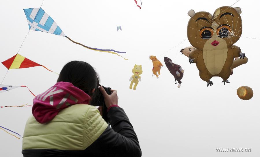 A photographer takes pictures of kites during a competition of flying kites in Weifang, east China's Shandong Province, April 6, 2013. A total of teams of contestants were involved and 1,164 kites were displayed on the event here on Tuesday. (Xinhua/Zhang Chi) 