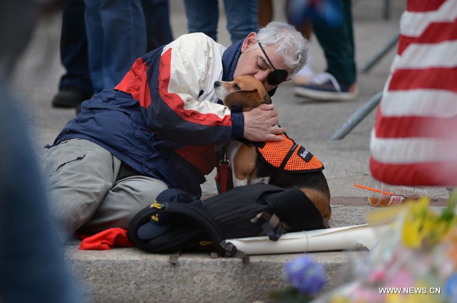 A citizen kisses his dog while mourning for the victims in Boston Marathon blasts in Boston, the United States, April 16, 2013. The death toll has risen to three, with 176 people injured. (Xinhua/Wang Lei) 