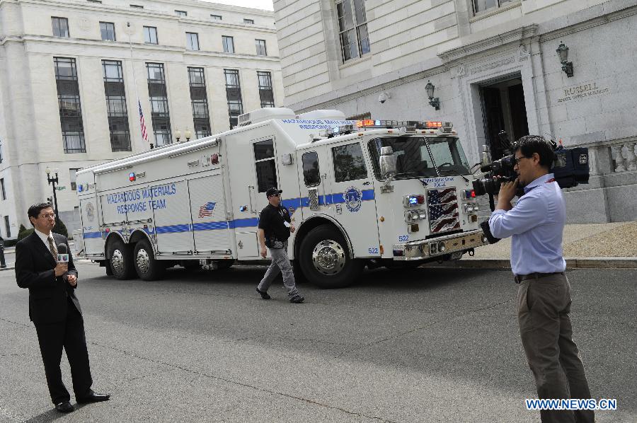 A cameraman reports near a hazadous materials response team truck outside the Russell Senate office building on Capitol Hill in Washington D.C., capital of the United States, April 17, 2013. U.S. Capitol Police on Wednesday evacuated the Hart and Russell Senate office buildings due to a suspicious envelop. (Xinhua/Zhang Jun) 