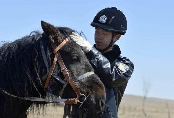  Wang Jiancheng, a ranger from East China’s Shandong province, grooms his horse at Zhenglanqi railway station in Xilinhot, North China’s Inner Mongolia autonomous region on April 16. A ranger team of eight policemen was set up at the railway station in May 2012 to better patrol the railway line in its jurisdiction, because harsh weather, complicated topography and heavy snow in winter often makes it impossible for local policemen to patrol the line in mobile vehicles. Seven of the rangers on the team are in their 20s. (Photo/Xinhua) 