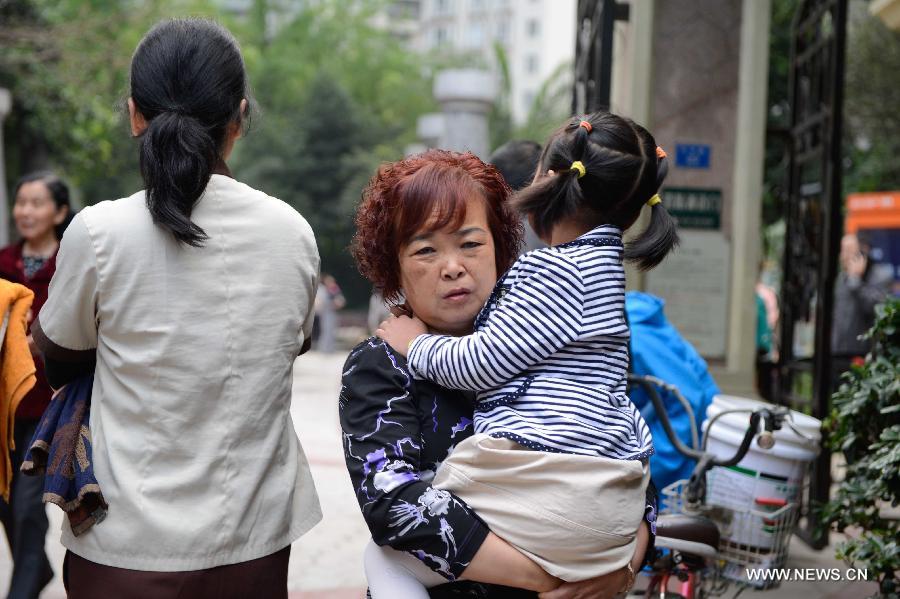 A woman holds her child outside her apartment to avoid aftershocks of a quake, in Chengdu, capital of southwest China's Sichuan Province, April 20, 2013. A 7.0-magnitude earthquake hit Lushan County of Sichuan Province at 8:02 a.m. Beijing Time (0002 GMT) on Saturday, according to the China Earthquake Networks Center (CENC). The epicenter, with a depth of 13 kilometers, was monitored at 30.3 degrees north latitude and 103.0 degrees east longitude. Residents in Chengdu felt the earthquake. (Xinhua/Li Qiaoqiao) 