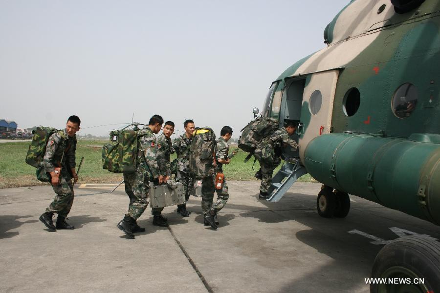 Military personnels, who carry out an rescue operation, board on helicopter flying for the quake-hit areas of southwest China's Sichuan Province, April 20, 2013. A 7.0-magnitude earthquake earthquake hit Lushan county of Ya'an City in Sichuan at 8:02 a.m. Saturday Beijing Time. At least 113 people were confirmed dead by far. (Xinhua/Xia Rui) 