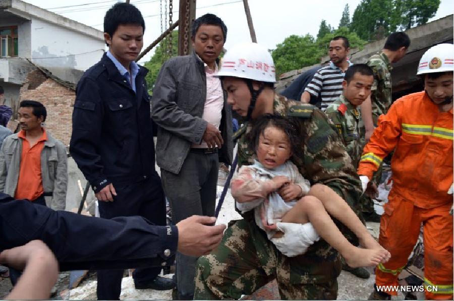 Firemen rescue a girl from debris in Lushan County of Ya'an City, southwest China's Sichuan Province, April 20, 2013. At least 113 people have been killed in the 7.0-magnitude earthquake in Sichuan Province as of 4:40 p.m. on Saturday, according to the provincial seismological bureau. (Xinhua)