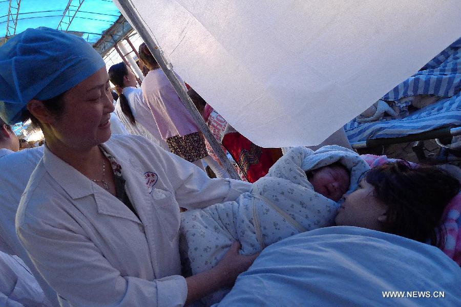A mother (R) views her newly-born baby in the quake-hit Ya'an City, southwest China's Sichuan Province, April 20, 2013. The baby was born in an ambulance in Ya'an, almost two hours after a 7.0-magnitude earthquake hit Lushan county of Ya'an City on Saturday. (Xinhua/Wang Dan) 