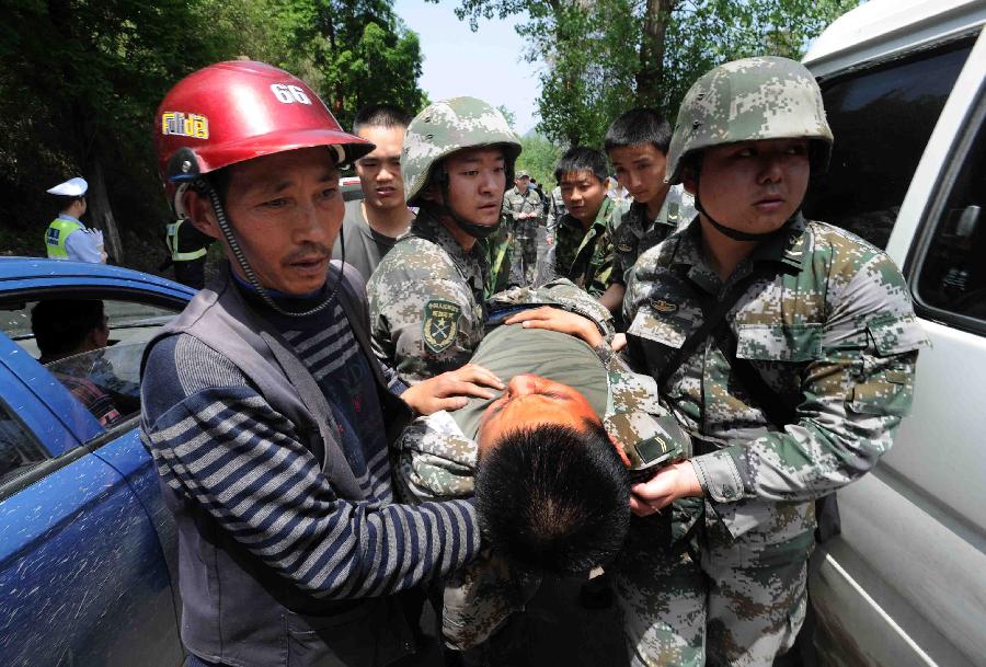 Rescuers carry out a soldier saved from a rescue car from Chengdu Military Region which falls off a cliff into a river in southwest China's Sichuan Province, April 20, 2013. Two of the 17 soldiers in the car have died by 11:30 p.m. Saturday Beijing Time. A total of 156 people have been killed in the 7.0-magnitude earthquake in Sichuan's Lushan as of 8:50 p.m. Saturday, according to the China Earthquake Administration. (Xinhua)  