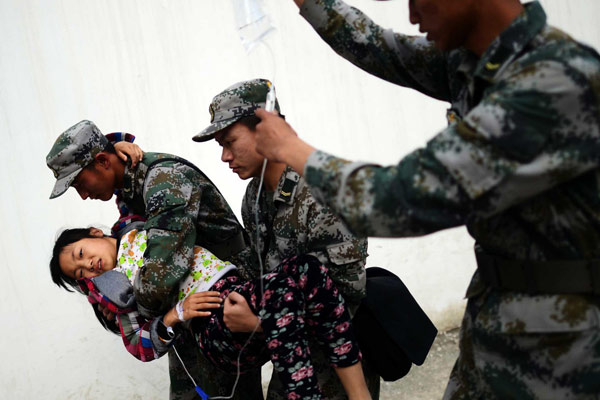 Rescue soldiers help a girl receive an infusion in Lushan county, Southwest China's Sichuan province, on April 20, 2013. A 7.0-magnitude earthquake struck the county on April 20, leaving at least 200 people dead and more than 10,000 injured. (Photo/Xinhua)