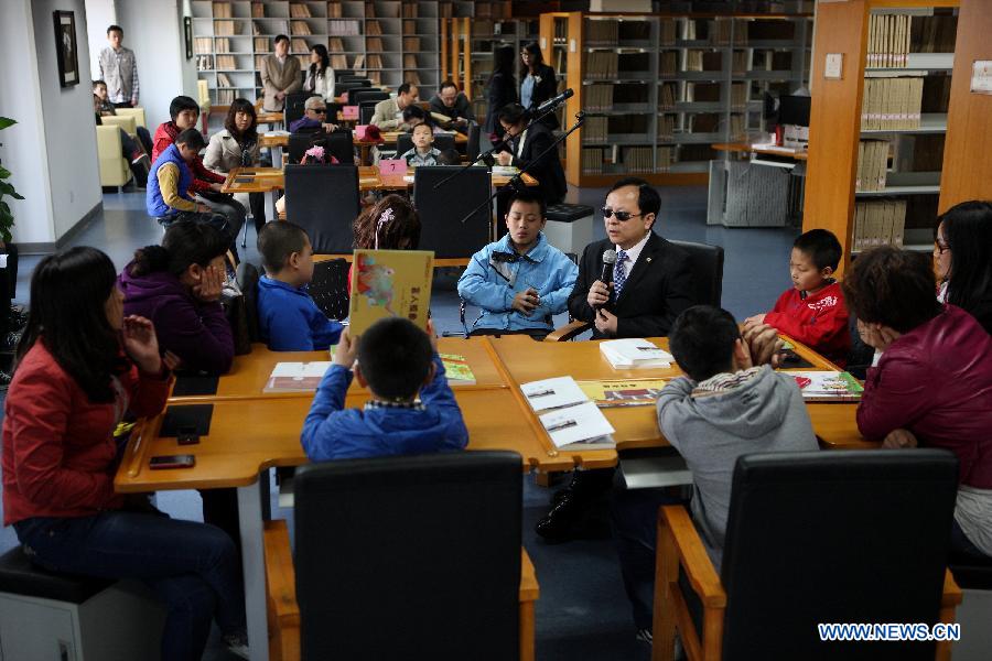 Photo taken on April 21, 2013 shows a reading party participated by visually impaired children in the China Braille Library in Beijing, capital of China, April 21, 2013. A reading party for the visually impaired children was held here on Sunday. Li Yanyan, a visually-challenged physician who achieved a medical doctor degree at Palmer West College of Chiropractic in California, the U.S., participated in the reading party with his autobiography and shared his learning experience with the young readers and their parents. (Xinhua/Xu Zijian) 