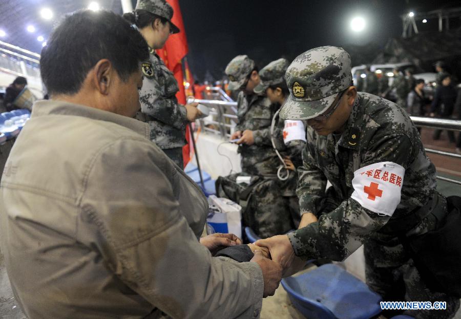 Military surgeons gives treatments to injured people at a public shelter in the quake-hit Baoxing County, southwest China's Sichuan Province, April 21, 2013. By far, a total of 28,000 people in the county have been evacuated to safety places. A 7.0-magnitude earthquake hit Sichuan at 8:02 a.m. Saturday Beijing time. (Xinhua/Luo Xiaoguang) 