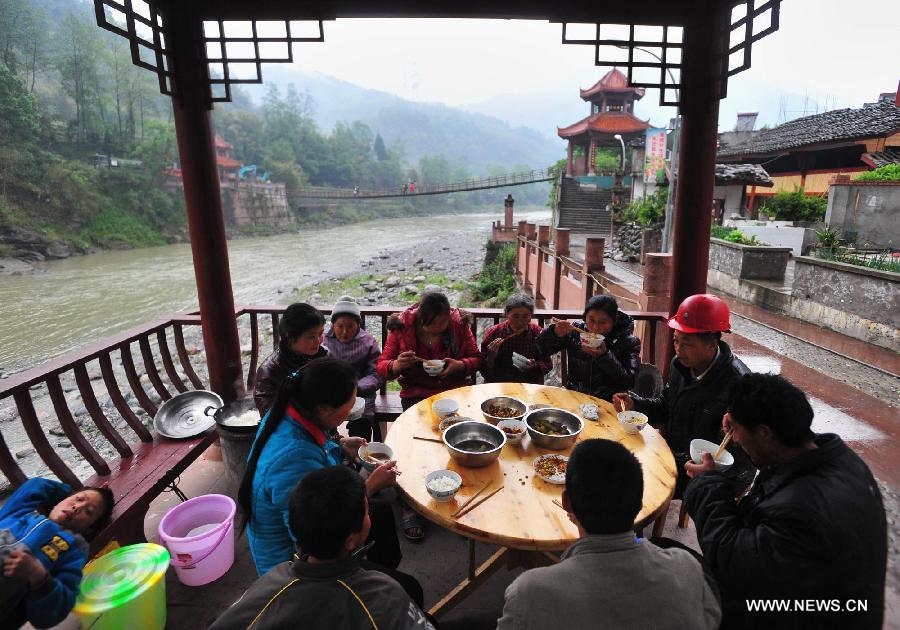 Villagers have dinner beside a river in quake-hit Yuxi Village of Lushan County, southwest China's Sichuan Province, April 23, 2013. A 7.0-magnitude jolted Lushan County on April 20. (Xinhua/Xiao Yijiu)