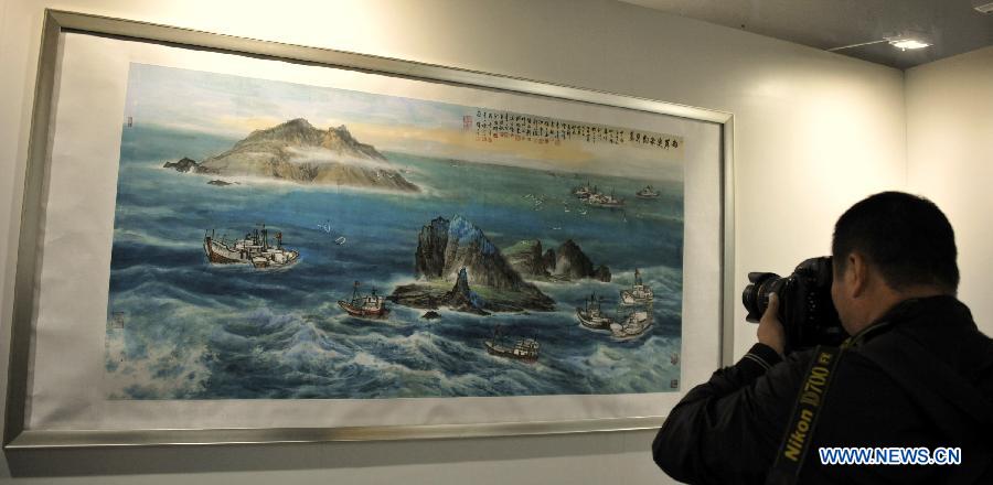 A visitor takes photo of a painting at an art exhibition themed on Chinese ocean in Beijing, capital of China, April 24, 2013. Over 130 pieces of artworks are on display. (Xinhua/Li Xin)