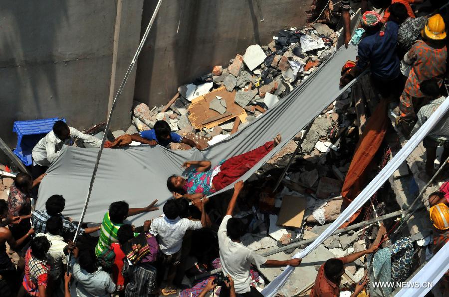 People rescue a woman after a building collapsed in Savar, Bangladesh, April 24, 2013. At least 70 people were killed and over six hundred injured after an eight-storey building in Savar on the outskirts of the Bangladeshi capital Dhaka collapsed on Wednesday morning. (Xinhua/Shariful Islam) 