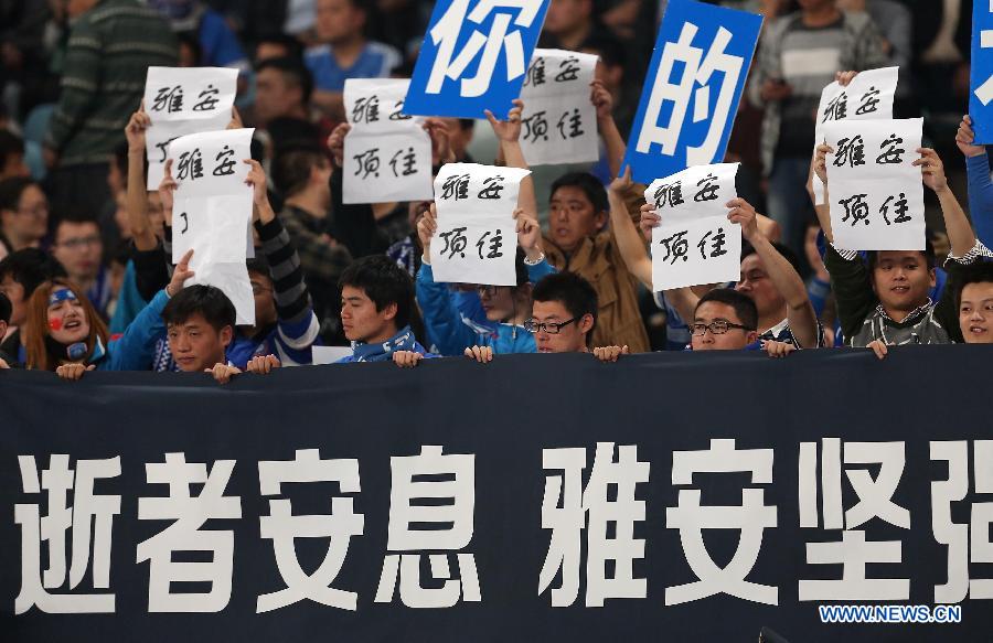 Audience hold posters to mourn for for the victims in the Lushan earthquake in southwest China's Sichuan Province during the AFC Champions League 2013 Group E match between China's Jiangsu Sainty and South Korea's FC Seoul in Nanjing, east China's Jiangsu Province, on April 24, 2013. FC Seoul won 2-0.(Xinhua/Yang Lei)