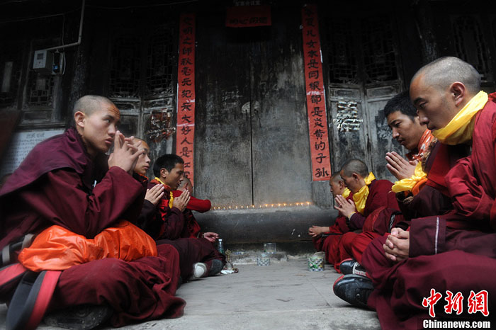 Photo taken on April 23 shows that Tibetan monks are praying for the victims and survivors of Lushan County's 7.0-magnitude earthquake in the epicenter Longmen Township, southwest China’s Sichuan Province. The 28 monks, from Lhagang Monastery in Garze Tibet Autonomous Prefecture, Sichuan Province, have walked for 6 hours before arriving here from the Lushan County.[Photo/Chinanews.com]