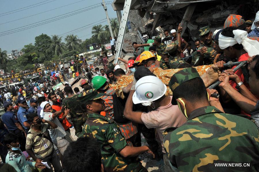 Rescuers carry a body recovered from the collapsed Rana Plaza building in Dhaka, Bangladesh, April 25, 2013. Rescue workers continued their struggle Thursday to reach many more who are feared trapped in the rubble one day after a building collapse in Savar on the outskirts of Bangladesh's capital Dhaka, with the death toll rising to 195. (Xinhua/Shariful Islam)