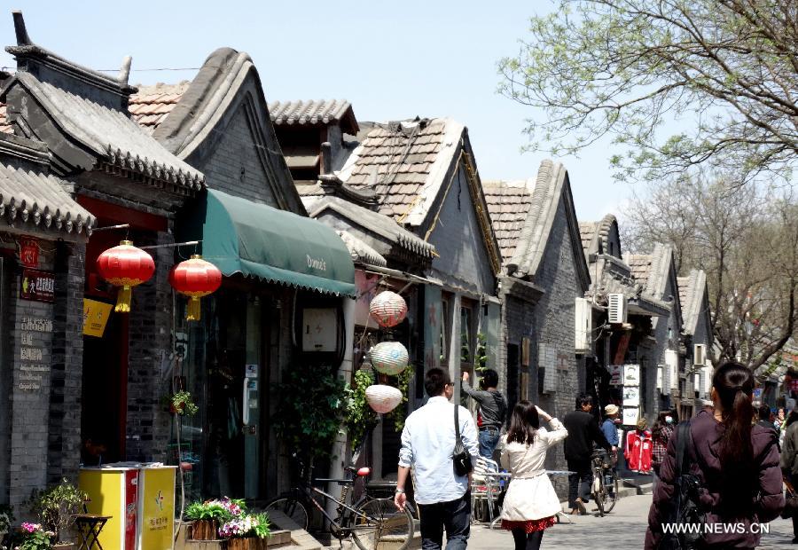 Photo taken on April 27, 2013 shows a view of old houses which has been renovated at Nanluoguxiang, one of Beijing's oldest hutong neighborhoods, in Dongcheng District in Beijing, capital of China. Local administration has taken a series of measures to protect Hutong, ancient architecture and courtyards in Dongcheng District, including renovation and putting up brands with Chinese-English bilingual introduction for old buildings. (Xinhua/Li Xin)  