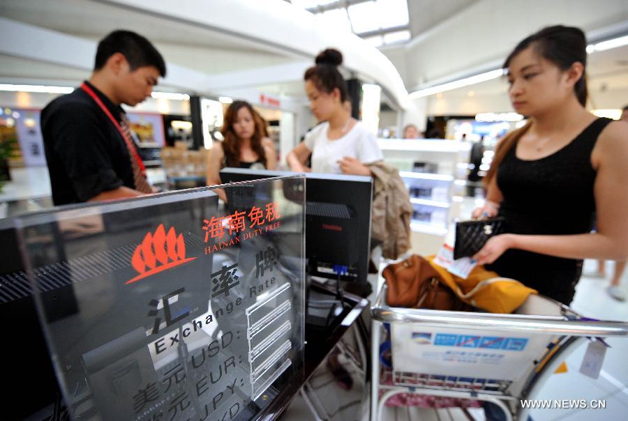 Visitors pay at the cashier desk at a duty-free shop at Haikou Meilan Airport in Hailou, capital of south China's Hainan Province, April 27, 2013. Data released by the provincial customs authorities on Friday showed that 1.94 million visitors have purchased goods worth 4.68 billion yuan (about 752 million dollars) as of April 20. The offshore duty-free program, put into place in April 2011 on a trial basis, is part of an effort to promote Hainan as an international tourist destination. (Xinhua/Guo Cheng) 