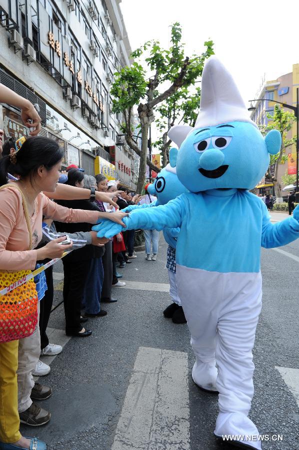 Actors dressing as the Smurfs interact with spectators in a cartoon and animation floats parade during the ninth China International Cartoon & Animation Festival in Hangzhou, capital of east China's Zhejiang Province, April 28, 2013. (Xinhua/Ju Huanzong) 