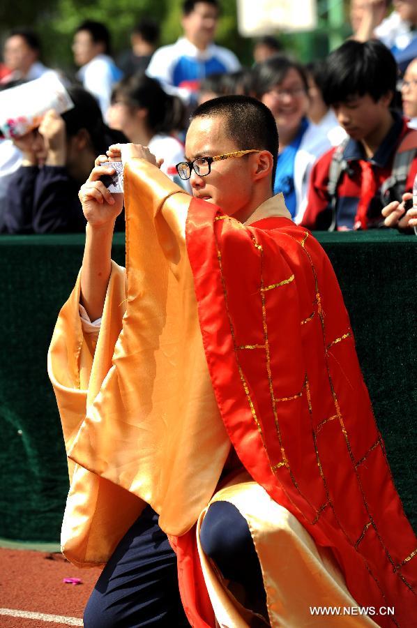 A student dressed as a Chinese monk take a photo during a costume parade in Tianyuan High School in Shanghai, east China, April 28, 2013. Teachers and students of the school dressed themselves as various real and fictional figures for a cross-culture costume parade here on Sunday. (Xinhua/Lai Xinlin) 