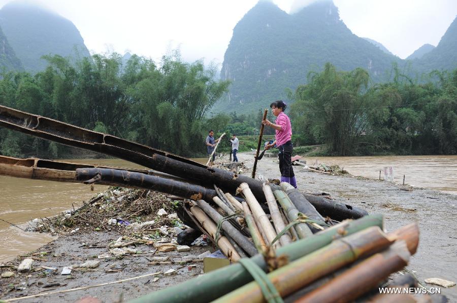Locals clear sundries in floods in Xiaochang'an Town of southwest China's Guangxi Zhuang Autonomous Region, April 30, 2013. Heavy rainfall hit Guangxi on April 29, making house damaged and causing floods and road cave-ins as well. (Xinhua/Wei Rudai)