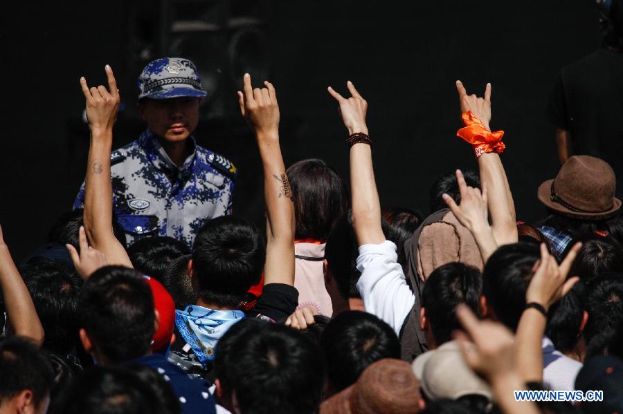 The audience gesture to respond to singers during the 5th Strawberry Music Festival at the Tongzhou Canal Park in Beijing, capital of China, April 30, 2013. The three-day festival kicked off here on April 29, involving some 160 performing teams from at home and abroad. (Xinhua/Bi Xiaoyang)