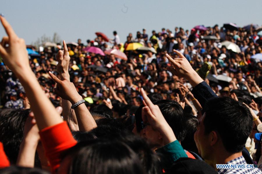 The audience gesture to respond to singers during the 5th Strawberry Music Festival at the Tongzhou Canal Park in Beijing, capital of China, April 30, 2013. The three-day festival kicked off here on April 29, involving some 160 performing teams from at home and abroad. (Xinhua/Bi Xiaoyang)