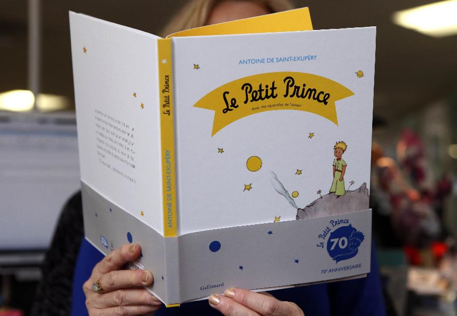 A woman reads a new edition of "The Little Prince" book on April 11, 2013 in Paris. France is marking the 70th anniversary of the world-loved "The Little Prince" with a host of special editions, including a new biography of its author, native son Antoine de Saint-Exupery. (Xinhua/AFP Photo)