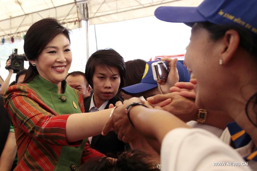 Thai Prime Minister Yingluck Shinawatra (1st L) shakes hands with workers when she arrives to attend a Labour Day celebration in Bangkok, capital of Thailand, May 1, 2013. (Xinhua/Rachen Sageamsak)