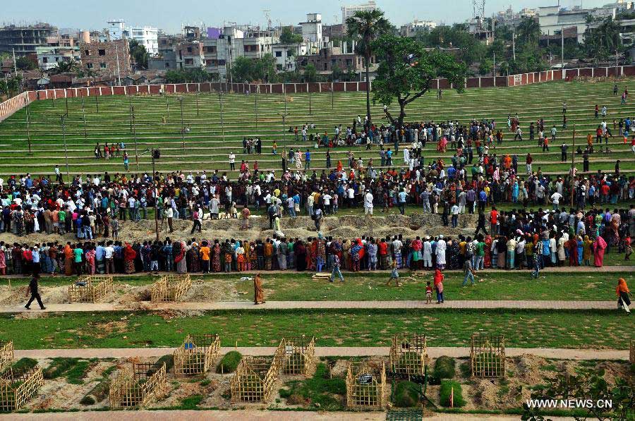 People gather at a cemetery during a mass funeral in Dhaka, Bangladesh, May 1, 2013. The collapse of the eight-storey Rana Plaza building has left so far about 400 dead. Thousand of garment workers staged a procession to mark International Labour Day in Dhaka, demanding the death penalty for the owner of the building. (Xinhua/Shariful Islam)