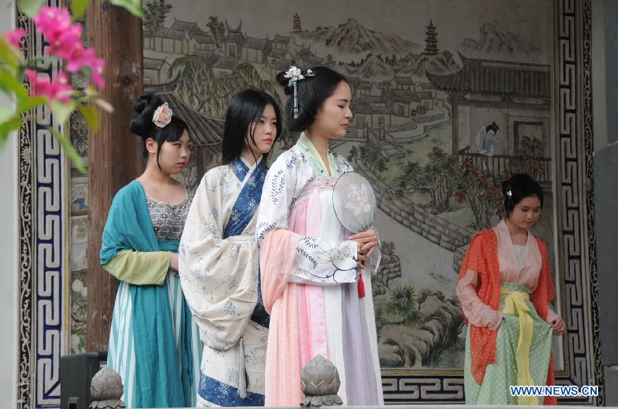 People wearing long robes of the archaic costumes typical of the Han Dynasty (202 BC - 221 AD) attend a presentation event promoting the Han costumes and traditional etiquette in Fuzhou, capital of southeast China's Fujian Province, May 1, 2013. (Xinhua/Lin Shanchuan)