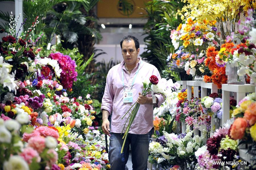 Rodrigo Quesada of Mexico purchases flowers at the 113th China Import and Export Fair, or Canton Fair, in Guangzhou, capital of south China's Guangdong Province, April 24, 2013. Nearly 25,000 companies, including 562 from 38 countries or regions are attending the fair, China's largest, attracting over 200,000 foreign buyers. (Xinhua/Liang Xu)