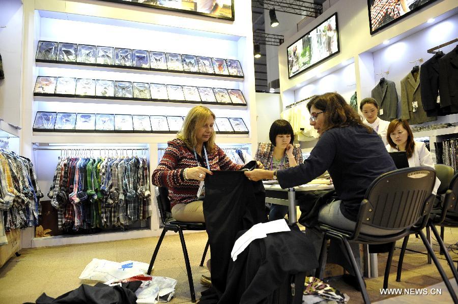 Roxana Villabona (1st L) and Sonia Costa (3rd L) of Uruguay purchases clothes at the 113th China Import and Export Fair, or Canton Fair, in Guangzhou, capital of south China's Guangdong Province, May 1, 2013. Nearly 25,000 companies, including 562 from 38 countries or regions are attending the fair, China's largest, attracting over 200,000 foreign buyers. (Xinhua/Liang Xu)