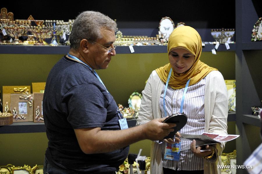 Hend Abdel Aziz and her father Mohamed of Egypt purchases craftworks at the 113th China Import and Export Fair, or Canton Fair, in Guangzhou, capital of south China's Guangdong Province, April 24, 2013. Nearly 25,000 companies, including 562 from 38 countries or regions are attending the fair, China's largest, attracting over 200,000 foreign buyers. (Xinhua/Liang Xu)