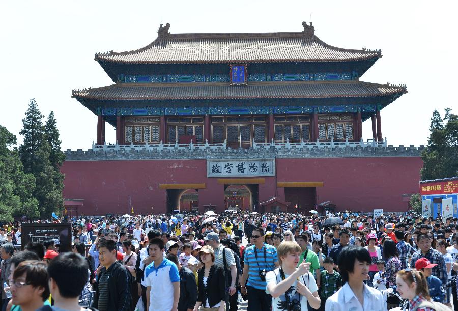 Tourists walk out of the Palace Museum in Beijing, capital of China, May 1, 2013. Beijing received 4.97 million trips during the three-day Labor Day holidays, up 5.1 percent over the same period of last year, with tourism revenues rising by 10.6 percent year on year to 1.987 billion yuan (about 323 million US dollars), according to the Beijing Tourism Development Commission. (Xinhua/Wang Quanchao)