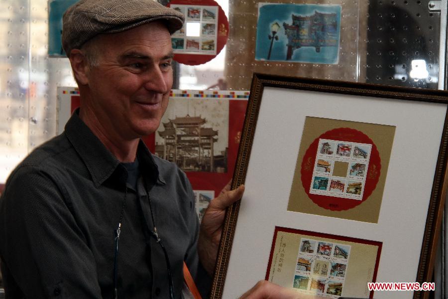 Illustrator Normand Cousineau displays the Chinatown Gates stamps in Ottawa, Canada, May 1, 2013. Canada Post launched a special series of stamps featuring Chinatown gates located in eight cities across the country on Wednesday to highlight the longstanding heritages of Chinese-Canadians. (Xinhua/Zhang Dacheng)