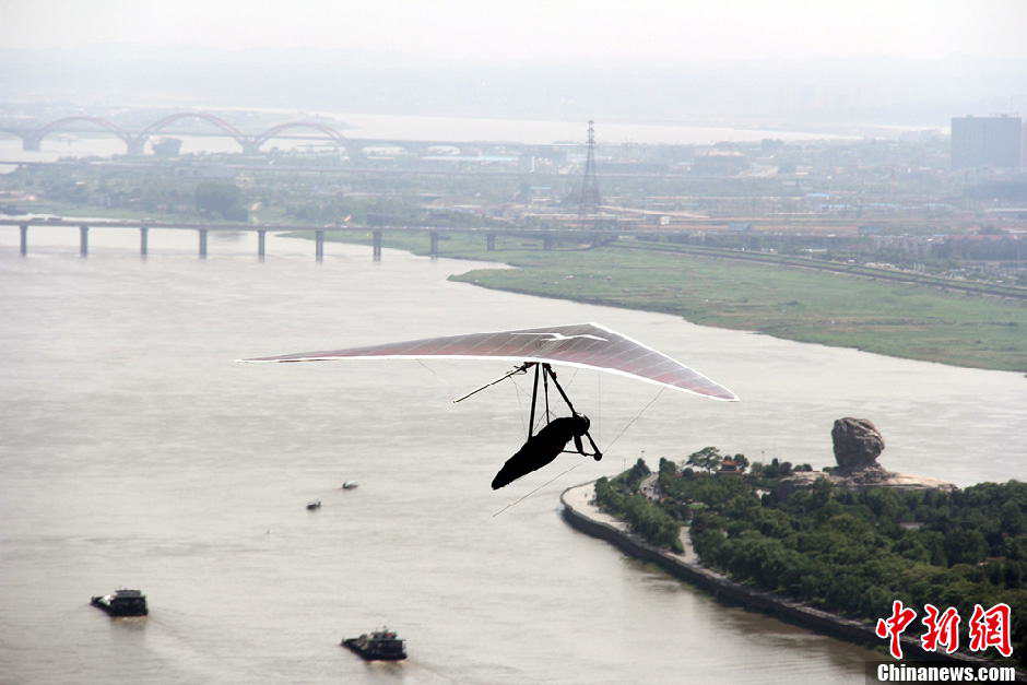 Yang Longfei, an amateur hang glider from Hebei province, soars across the Xiang River in Changsha, Central China's Hunan province, May 1, 2013. After successfully covering a distance of 1,500 meters, Yang became the first person in the world to complete an unpowered flight within a city. (Photo/Chinanews.com)