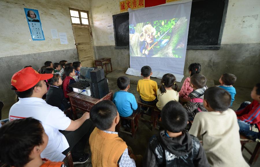 Pupils of the Shahu Elementary School watch movies at a temporarily-erected "cinema" in Jingkou Township of Nanchang County, east China's Jiangxi Province, May 2, 2013. Volunteers in Jingkou Township organized a film projection team and projected films in 23 elementary and middle schools for students, most of whom had never seen a movie before. (Xinhua/Zhou Ke)