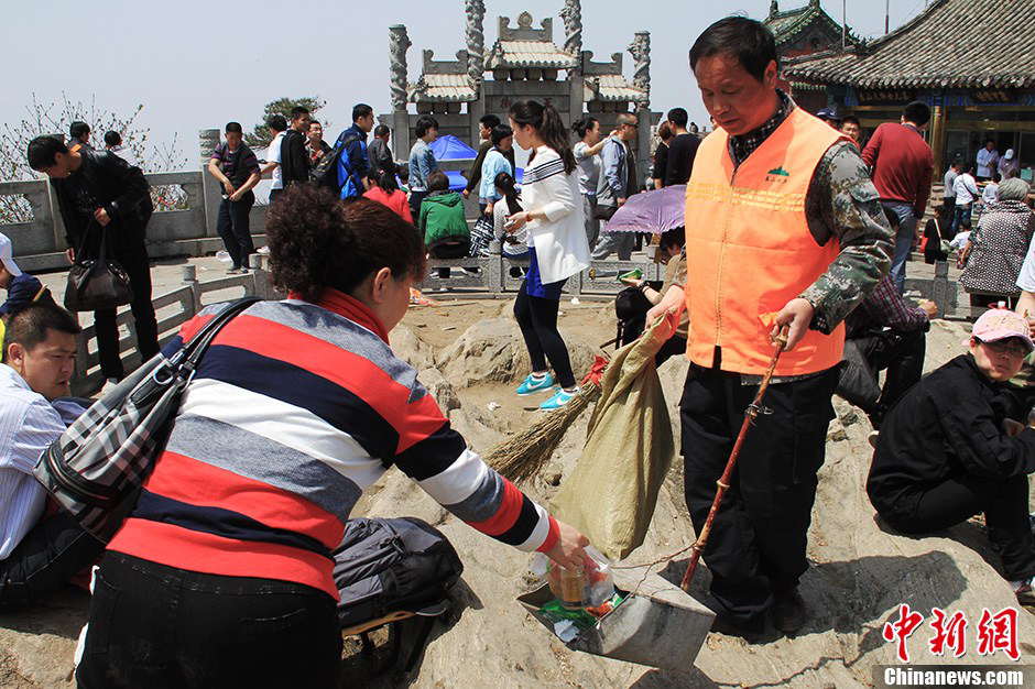 Tourists consciously hand the garbage to Zhang. (Photo by Li Xianglei/ Chinanews.com)