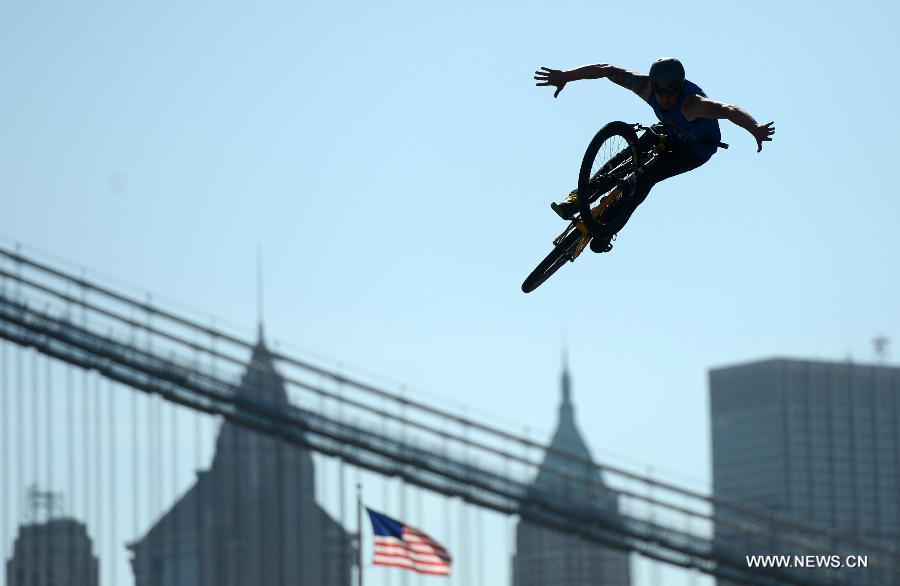 A man shows his biking tricks during the 2013 Bike Expo New York in New York City, the United States, May 3, 2013. (Xinhua/Wang Lei) 