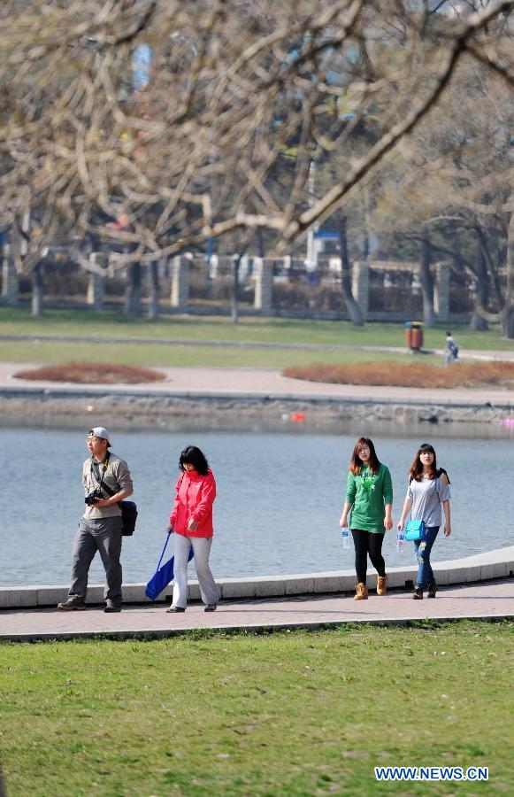 People walk along the lake bank of the Nanhu Park in Changchun, capital of northeast China's Jilin Province, May 5, 2013. Sunday is the beginning of the 7th solar term in Chinese lunar calendar, which indicates the coming of summer. The temperature in Jilin rebounded in recent days. (Xinhua/Zhang Nan)