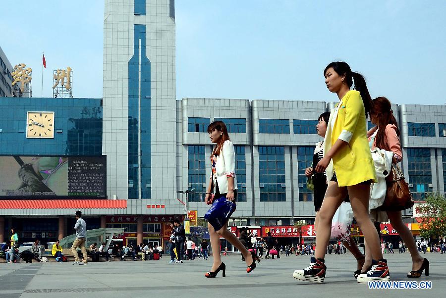 Women wearing summer clothing walk on the square of the railway station in Zhengzhou, capital of central China's Henan Province, May 5, 2013. Sunday is the beginning of the 7th solar term in Chinese lunar calendar, which indicates the coming of summer. The temperature in Henan rebounded in recent days. (Xinhua/Wang Song)