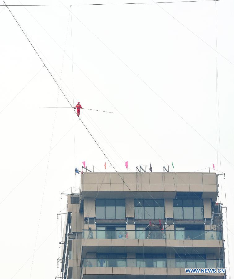 Tightrope walker Adili Wuxor, with his eyes blindfolded, walks on a steel wire that is 106-meters above the ground near Desheng River in Hangzhou, east China's Zhejiang Province, May 5, 2013. Adili successfully finished a series of performances here on Sunday. (Xinhua/Xu Hui)