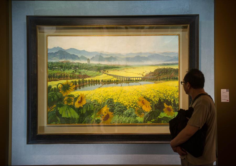 A visitor looks at a painting during the preview of China Guardian 2013 Spring Auctions in Beijing, capital of China, May 7, 2013. The three-day preview that opened on Tuesday displayed some 3,900 treasures to be auctioned on Friday. (Xinhua/Luo Xiaoguang) 