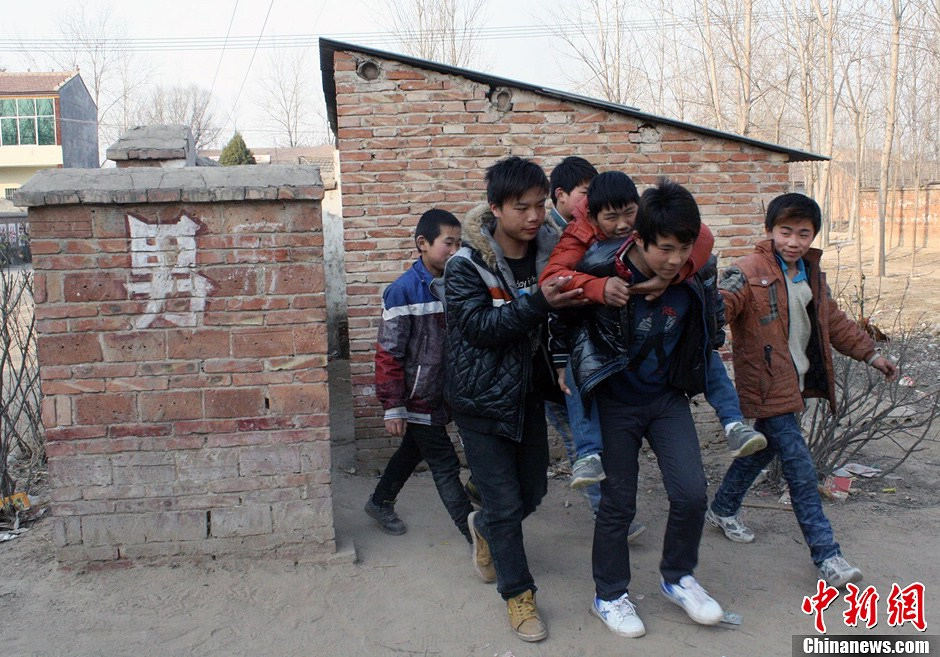 The classmates carry Zongcheng to toilet. (CNS/Hu Ying)