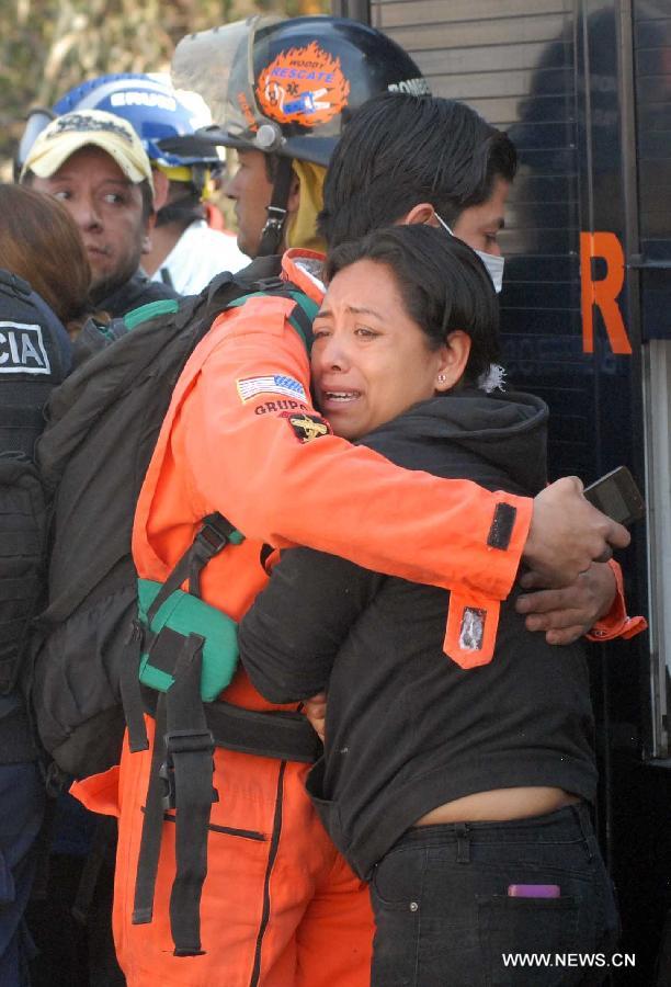 A rescuer consoles a victim's relative at the site of an explosion on the Mexico-Pachuca highway in Ecatepec, Mexico, on May 7, 2013. At least 20 people were killed and 34 injured when a gas tanker exploded early Tuesday in a Mexico City suburb, security officials said. (Xinhua/Susana Martinez) 